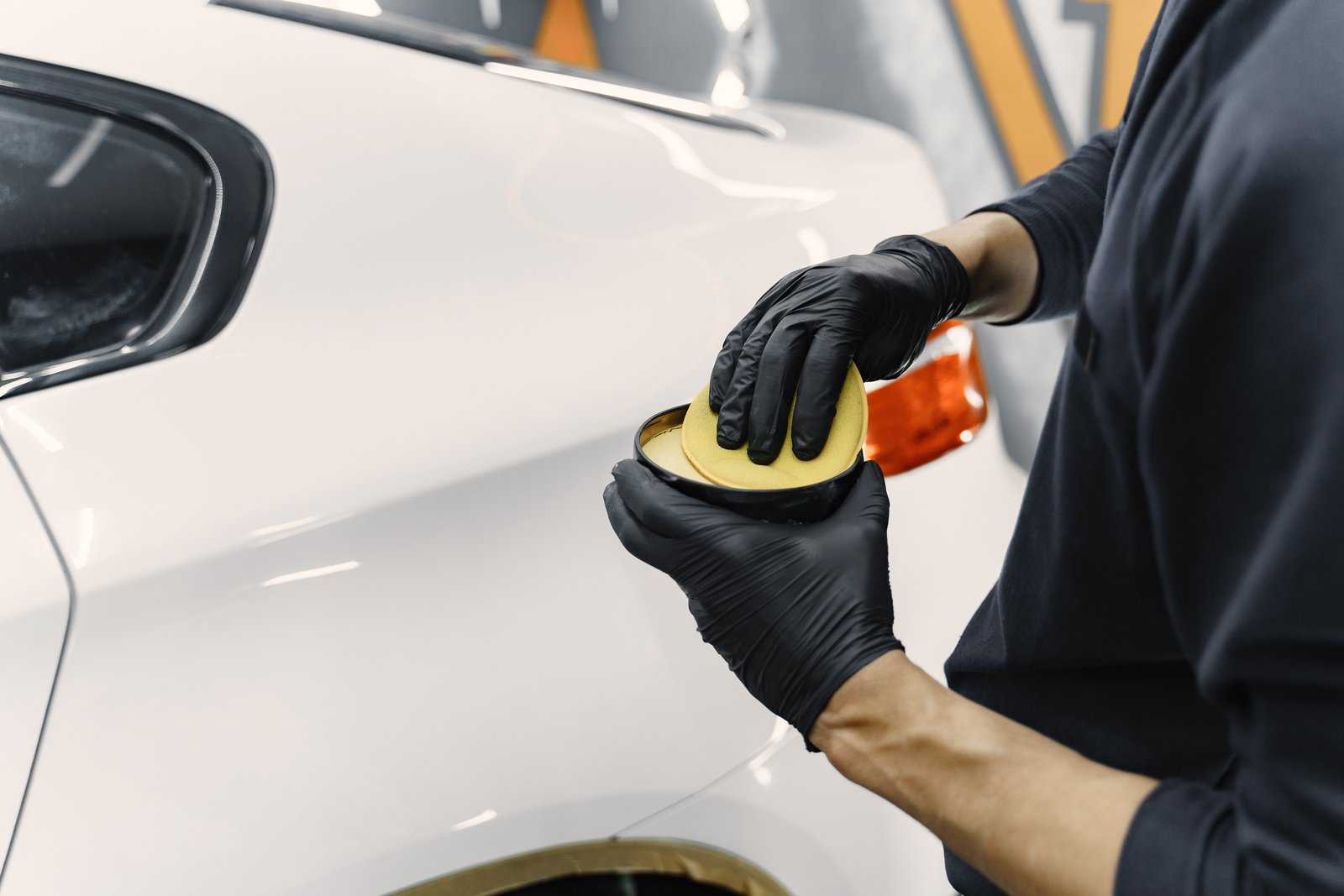 Hands applying ceramic coating to a car panel
